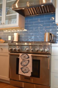 ocean blue tile backsplash in a kitchen at the timbers kiawah ocean club residences by j banks design group