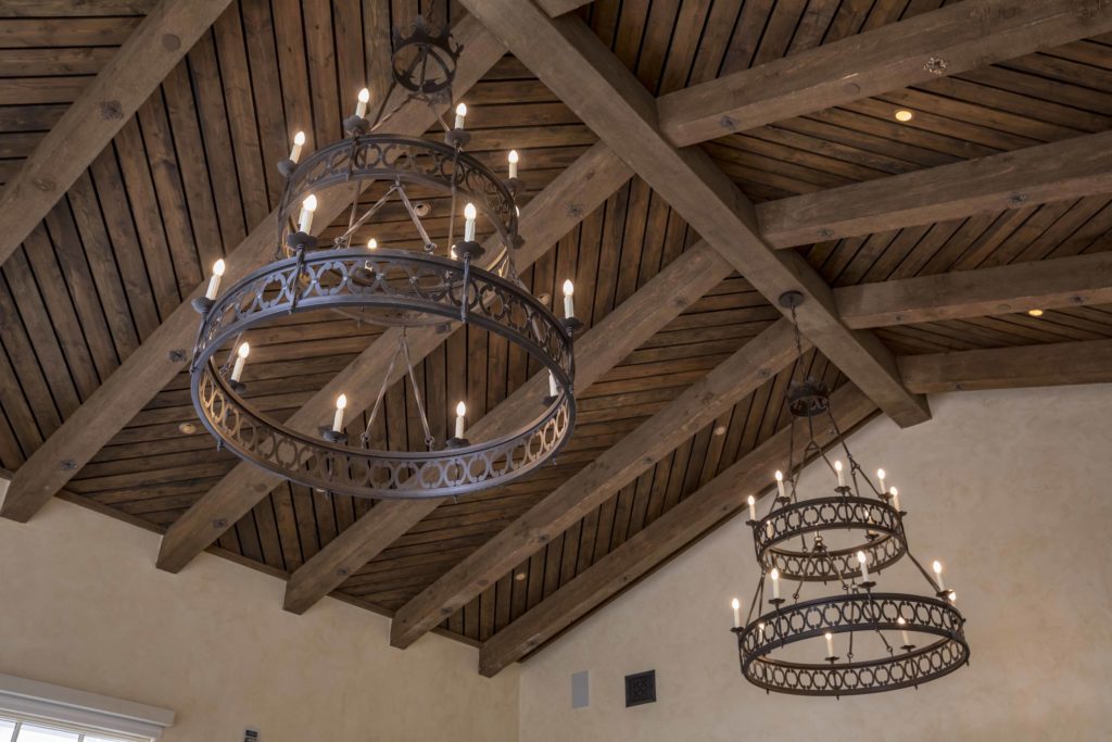 large iron chandeliers hang in the monterey peninsula country club sourced by j banks design group