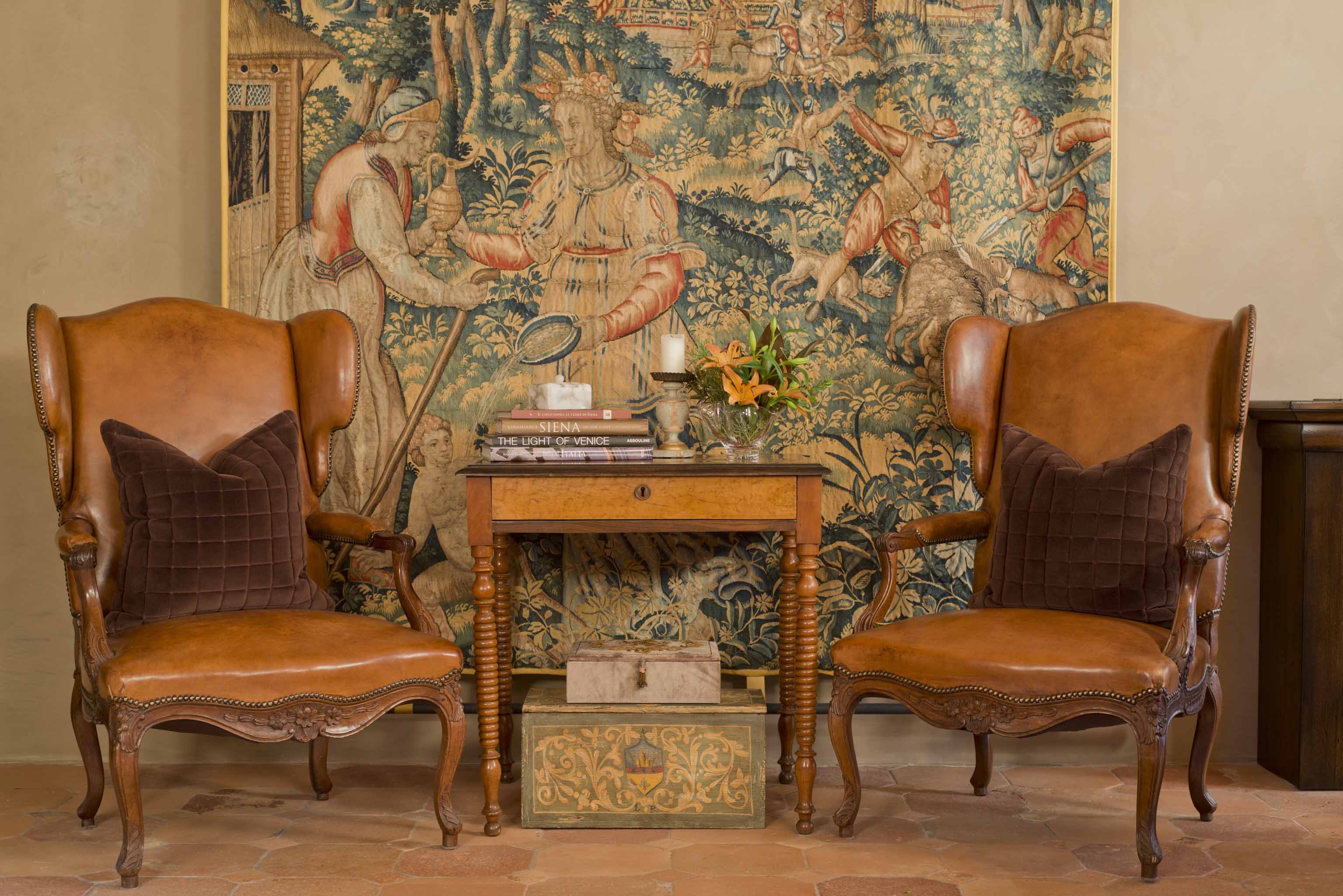 hotel castello di casole interior design featuring comfortable armchairs and an antique tapestry