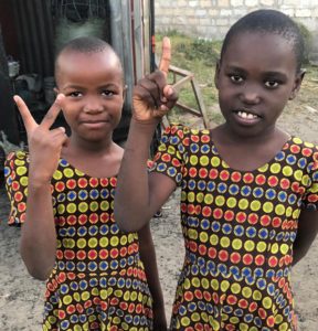 two smiling girls counting at valentine project children's home-dar es salaam, tanzania