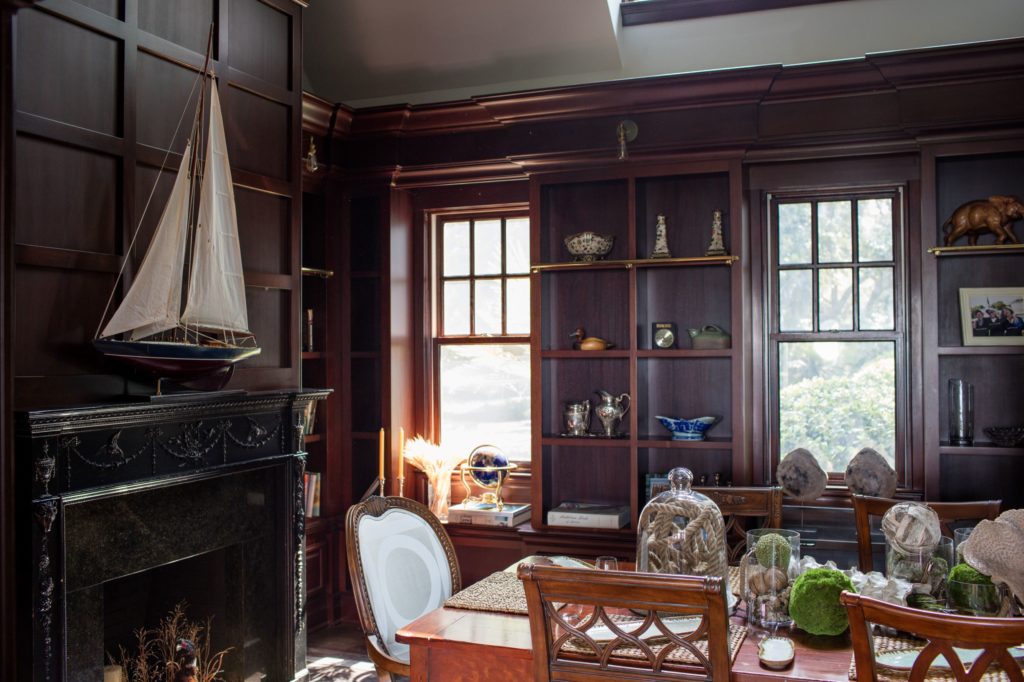 A man's office with conference table and model sailboat and yacht racing trophies