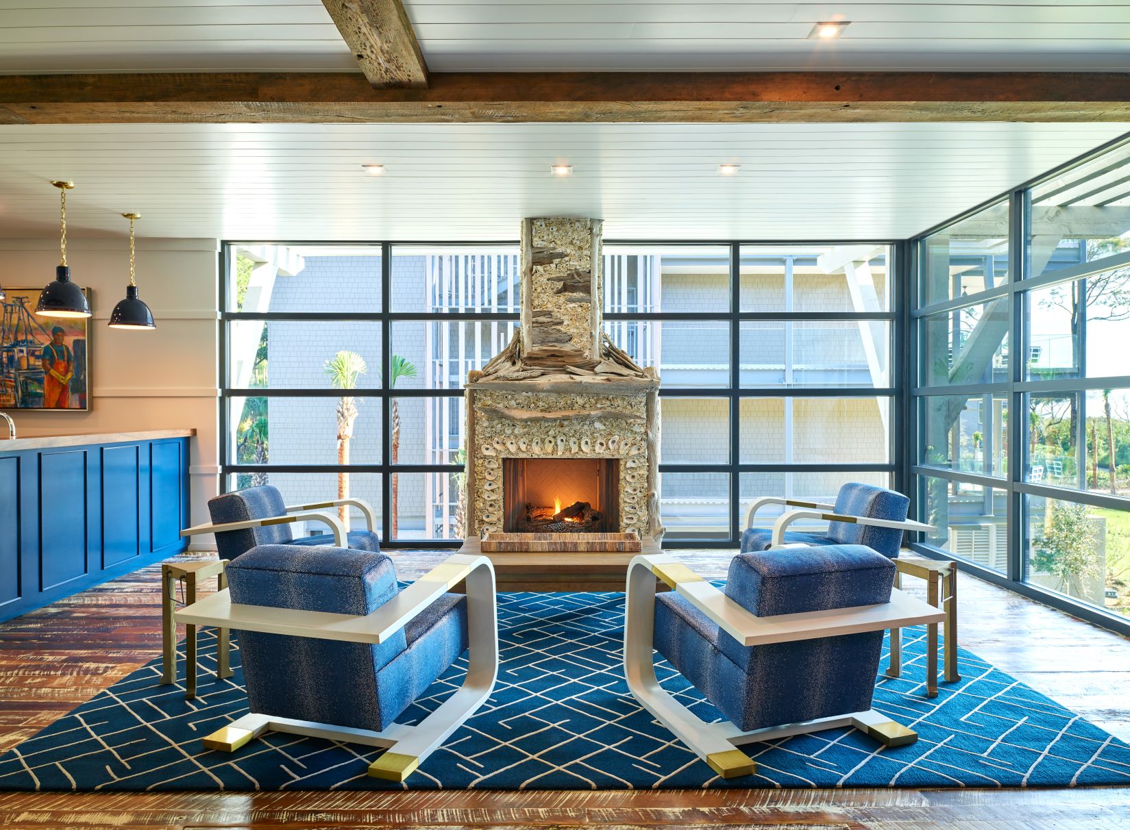 Tabby and driftwood fireplace surrounded by whote and brass lounge chairs at Timbers Kiawah Clubhouse on Kiawah Island