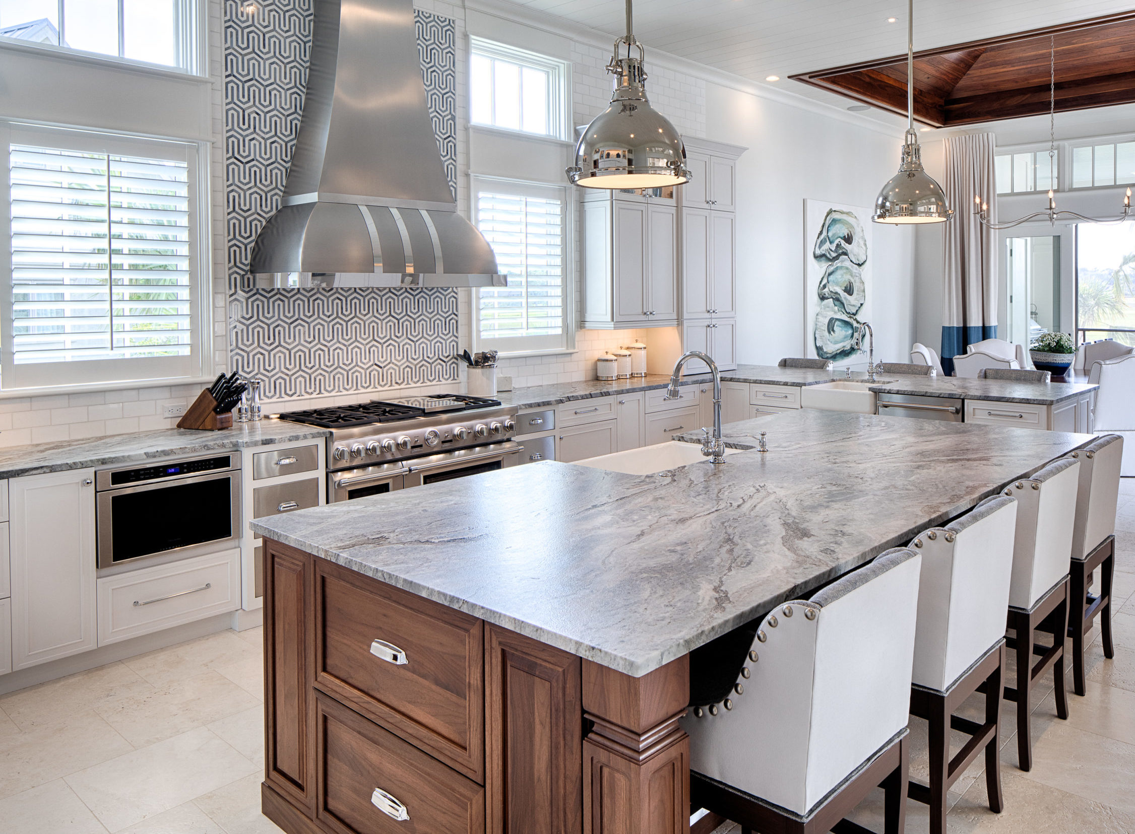 Lowcountry kitchen with graphic black and white tile behind stove, marble counter tops and dark wood island designed by Hannah Toney